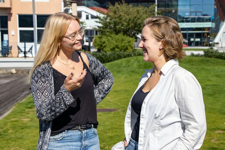 Bilde av to kvinner som smiler og ser på hverandre mens det ser ut som de er i dialog